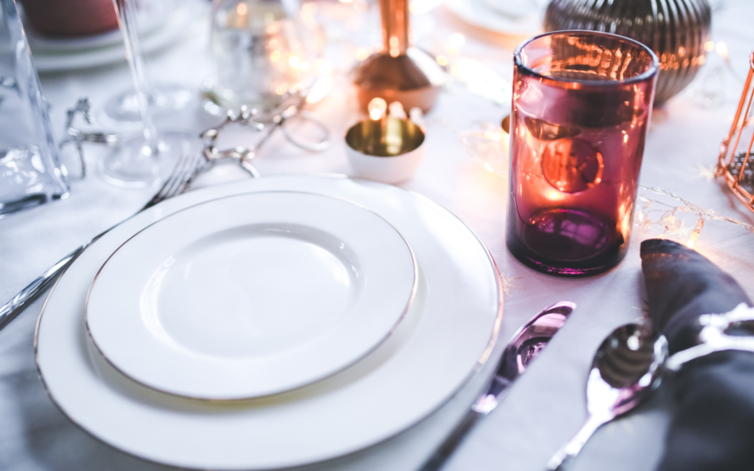 Mesa de restaurante con vajilla de porcelana blanca, copas de vino, vasos y cubertería profesional bien presentada